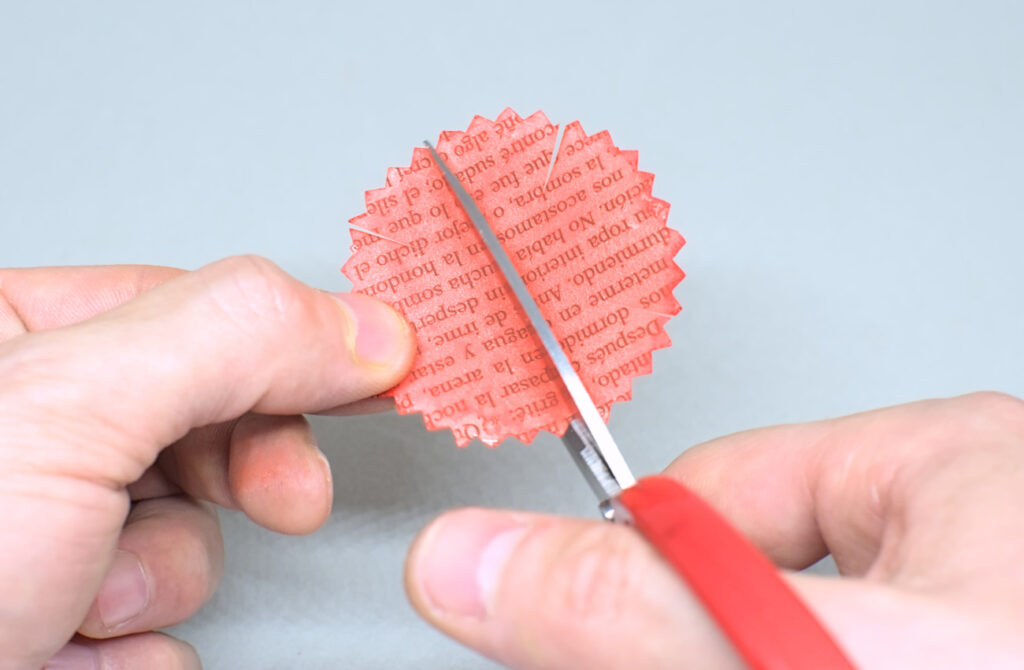 haciendo cortes diagonales con tijeras en circulo de papel dentado