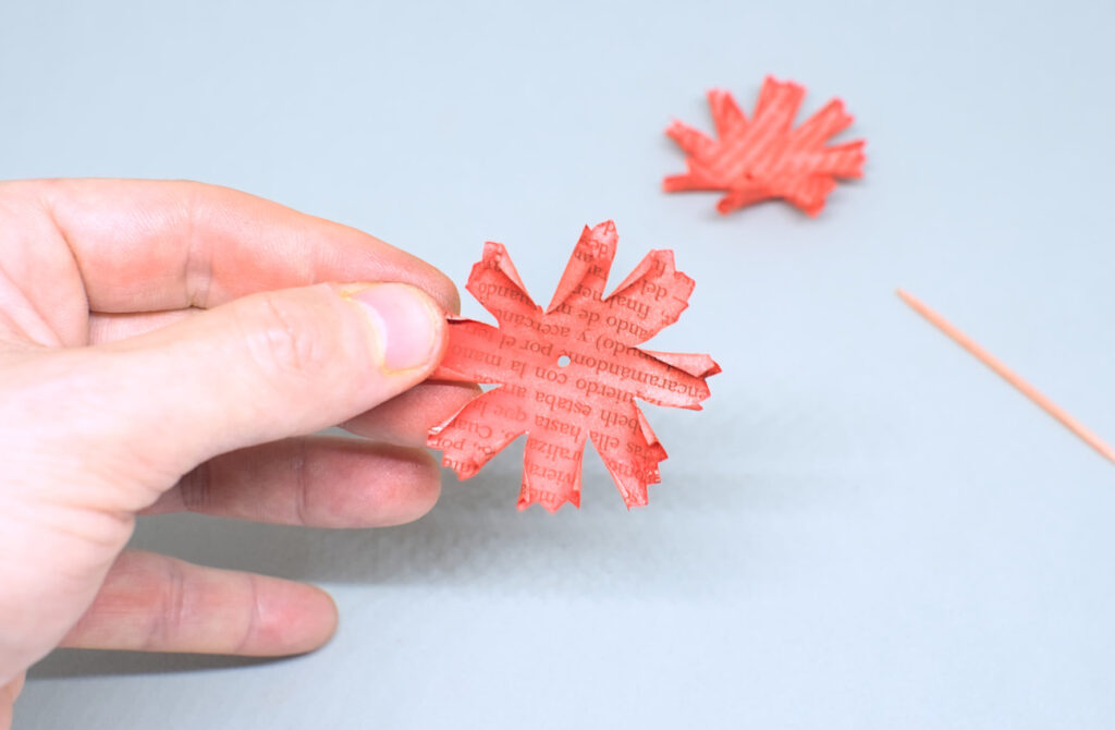 orificio hecho en el centro de hoja de papel con forma de petalos de clavel