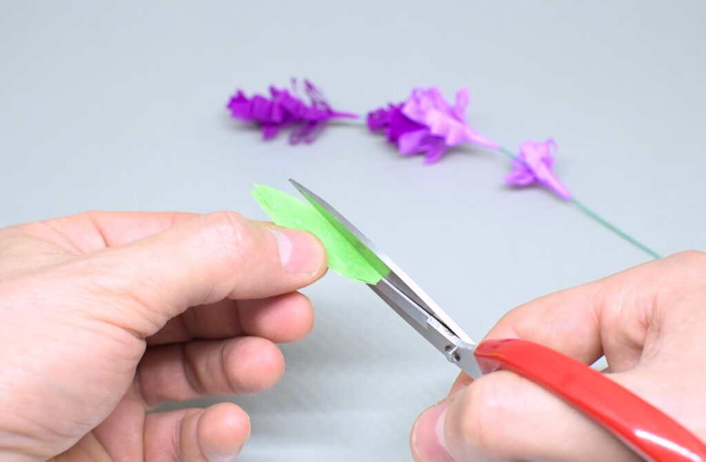 pequeño corte en hojas simetricas de papel crespon verde