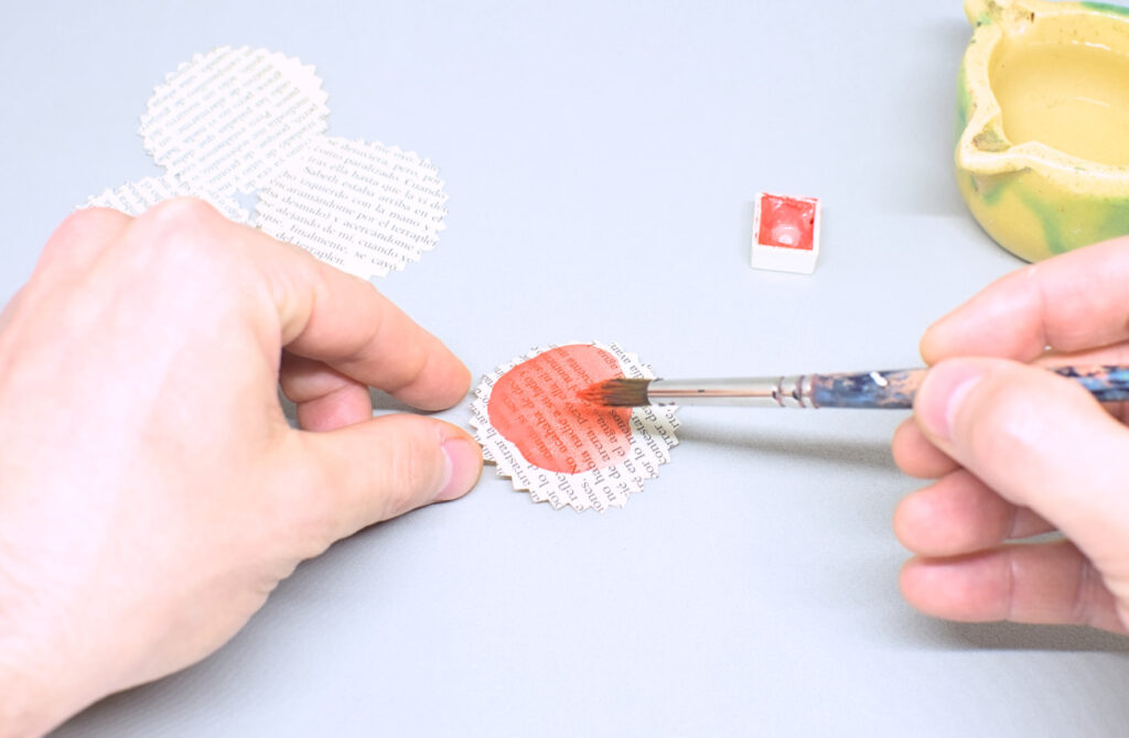 pintando circulos de papel dentado con acuerala en color rojo
