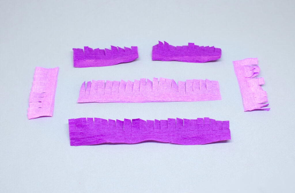 tiras dobladas con flecos de papel crespon de colores