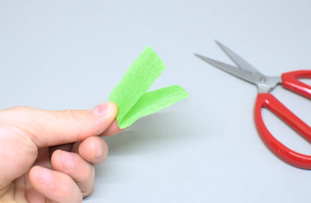 trozo de papel crespon verde doblado por la mitad