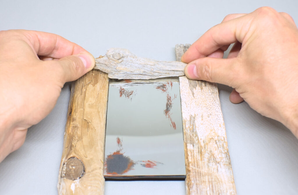 adhiriendo pequeño trozo de madera de deriva para hacer moldura para espejo