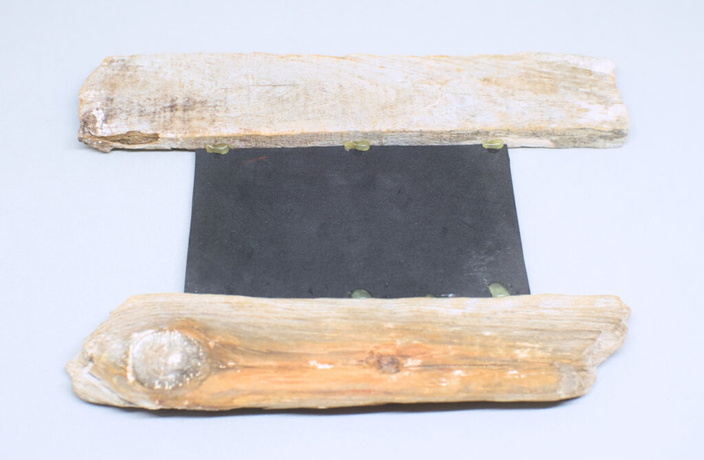 espejo y fragmentos de madera de deriva adheridos con silicona caliente