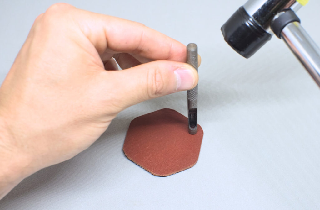 perforando orificio en pieza de cuero hexagonal con sacabocados