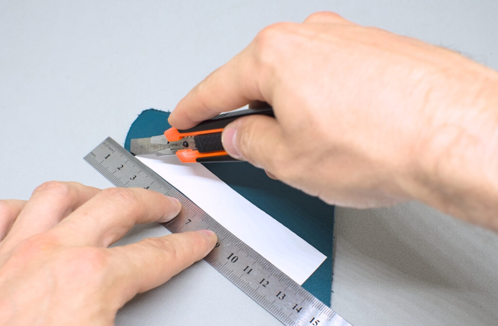 cortando tira de cuero verde oscuro de 12 cm para funda de abanico