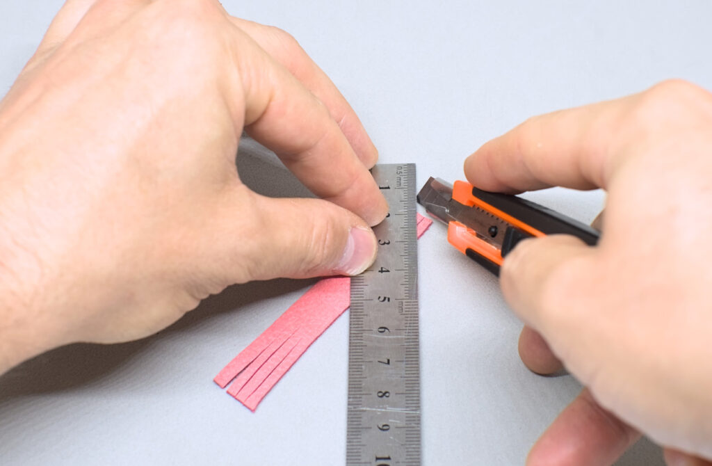 haciendo cortes diagonales en extremos de tira de cuero con flecos
