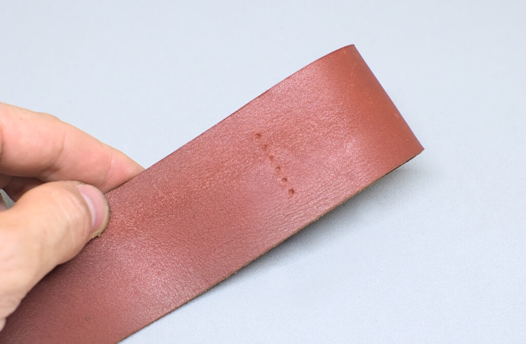 linea de costura perforada entre anilla y funda de cuero para abanico