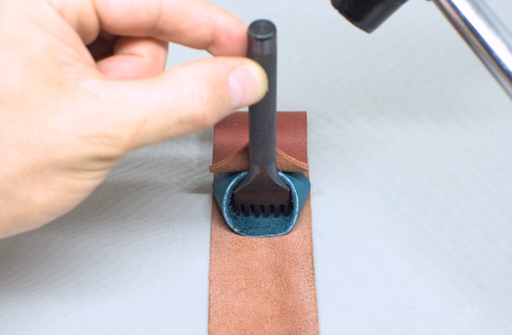 perforando orificios de linea de costura entre anilla y funda de cuero para abanico